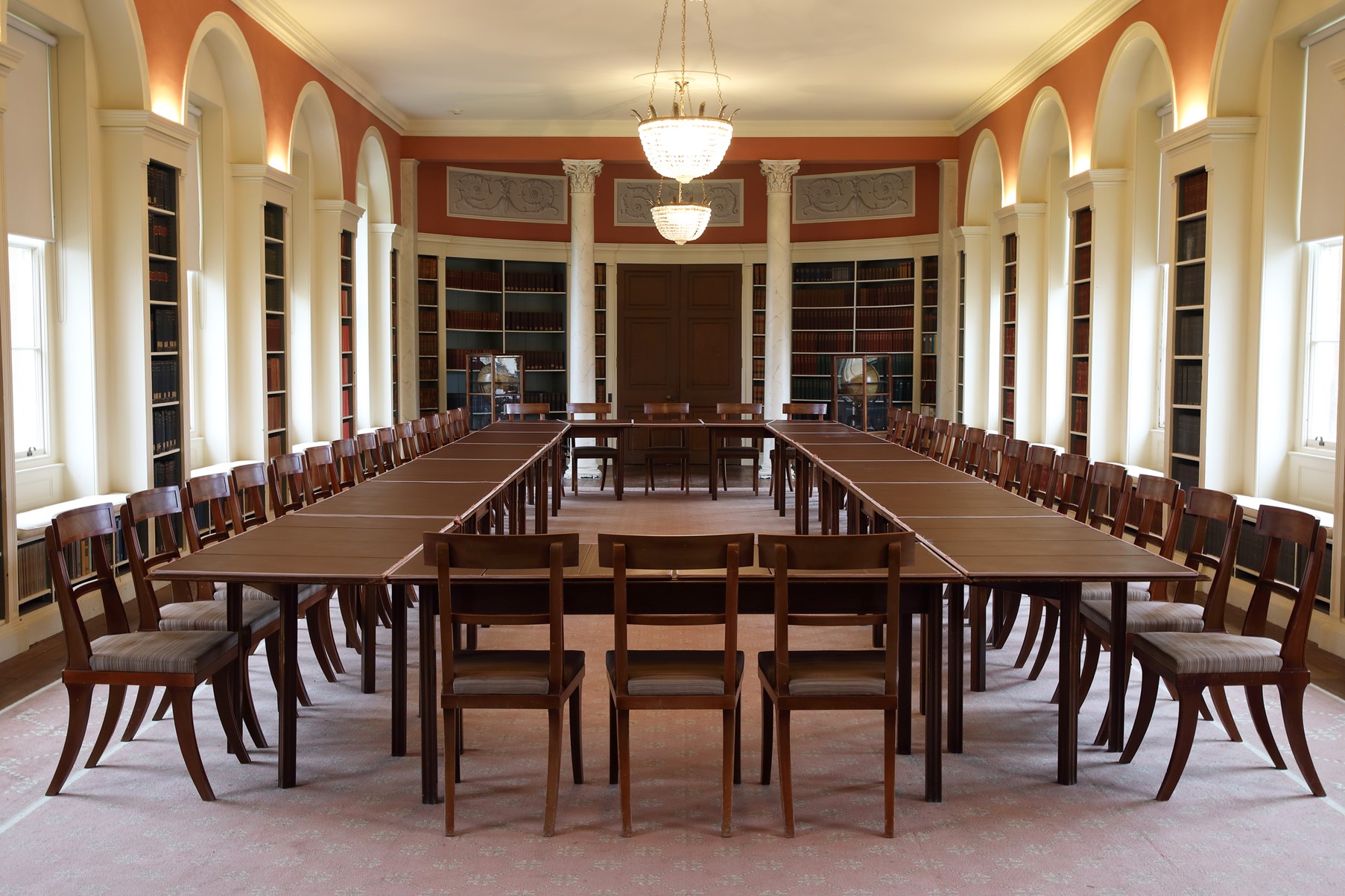 McGregor Matthews Room - a grand boardroom with a large brown meeting table. Books are placed in bookshelves either side.